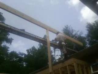 Carpenter setting a ridge beam over a new addition frame — Ice Dam Removal by Roofing Brothers in Media