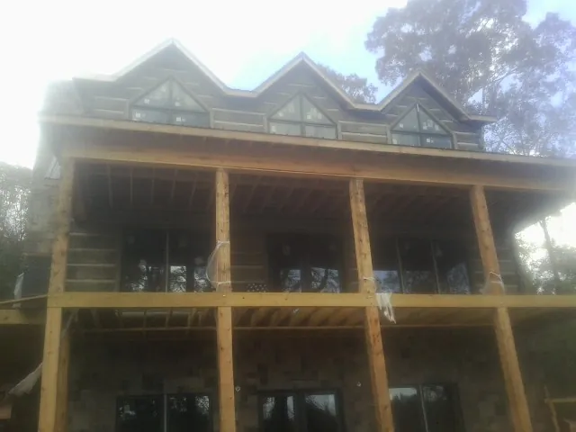 Dormers and porch framing on a large log home under construction — Roof Coating work by our crew in Media