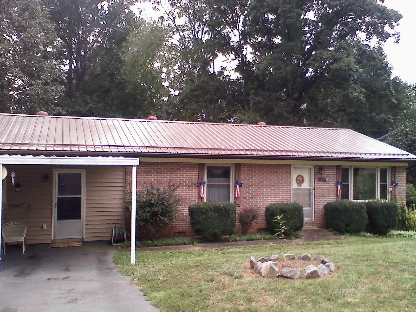 Bronze metal roof and carport on a brick ranch home — Roof Repair work by our crew in Media